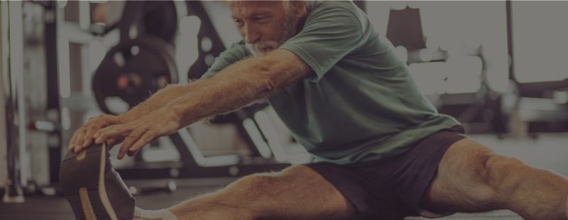 Mann dehnt sich im Fitnessstudio